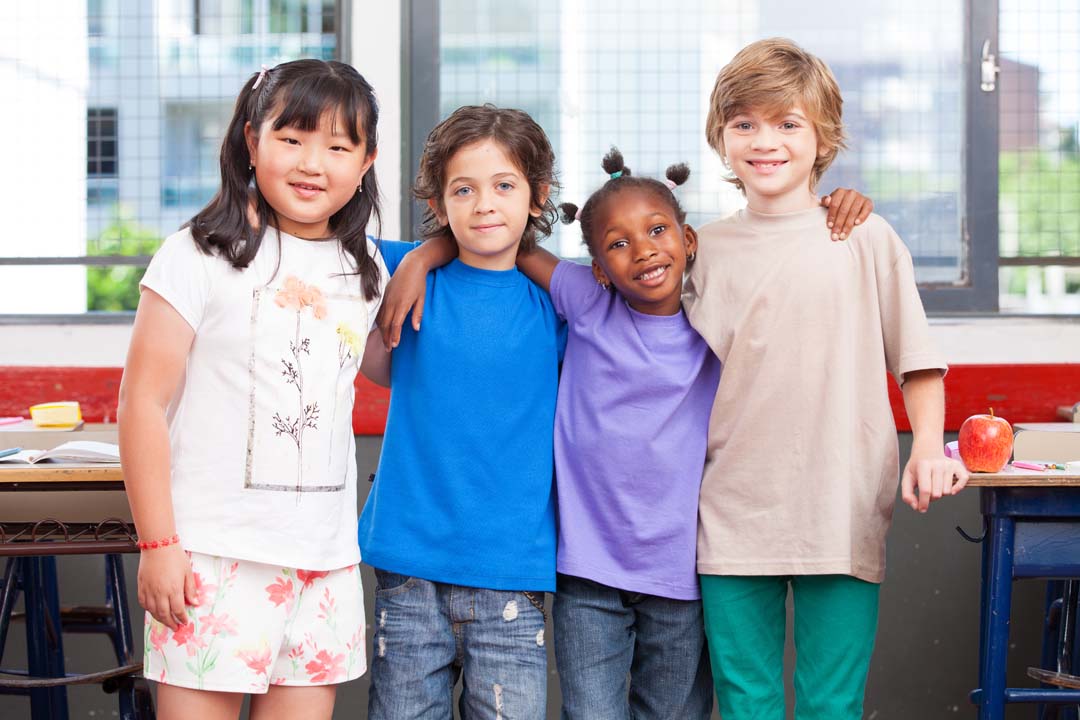 Four students standing in a classroom