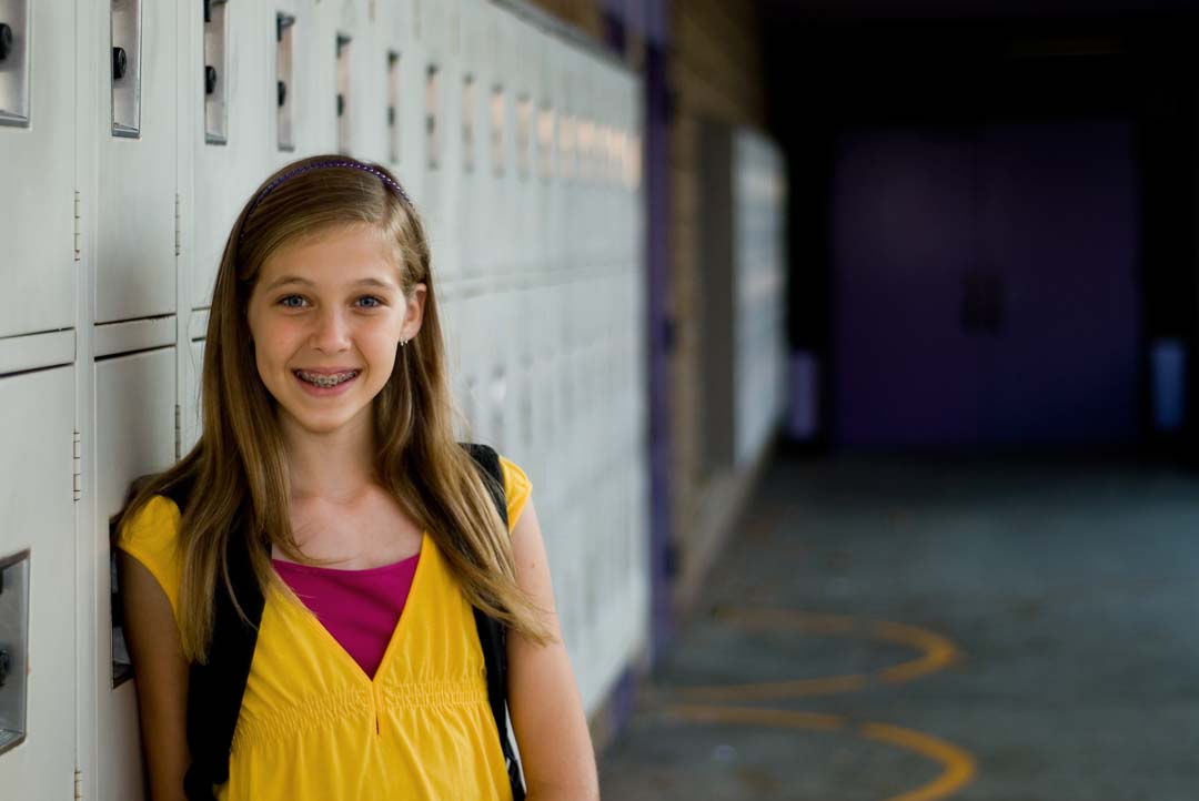 student standing in the hall near the lockers