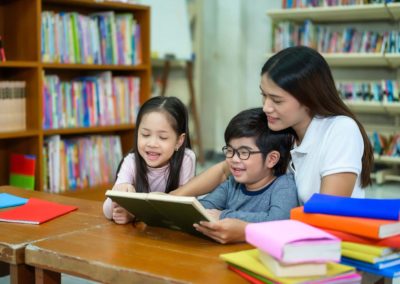 Students reading a book with a teacher