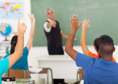 Students with their hands raised in a classroom