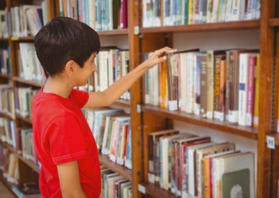 student in a library getting a book