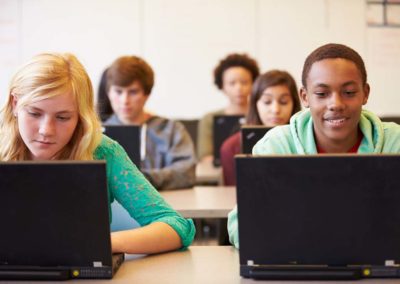 Group Of High School Students In Class Using Laptops