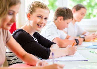Students or pupils of school class writing an exam test in classroom concentrating on their work