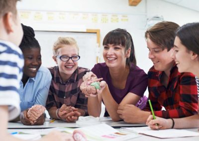 Teenage Students With Teacher In Biology Class